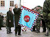 Prezident Slovenské republiky Rudolf Schuster připíná stuhu na bojovou zástavu Česko-slovenského praporu KFOR na náměstí Svornosti v Českém Krumlově, 25. ledna 2002, foto: Lubor Mrázek