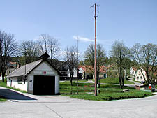 Tsov - Dorfplatz mit dem Feuerwehrzeughaus im Vordergrund, Foto: Jan K